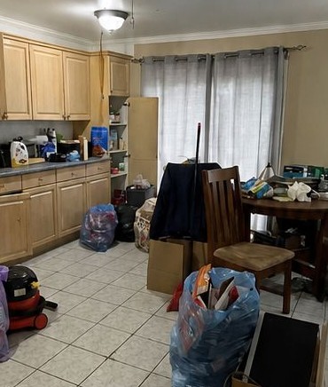 Kitchen before an Aurofresh clean, with clutter and boxes covering the floor and counters