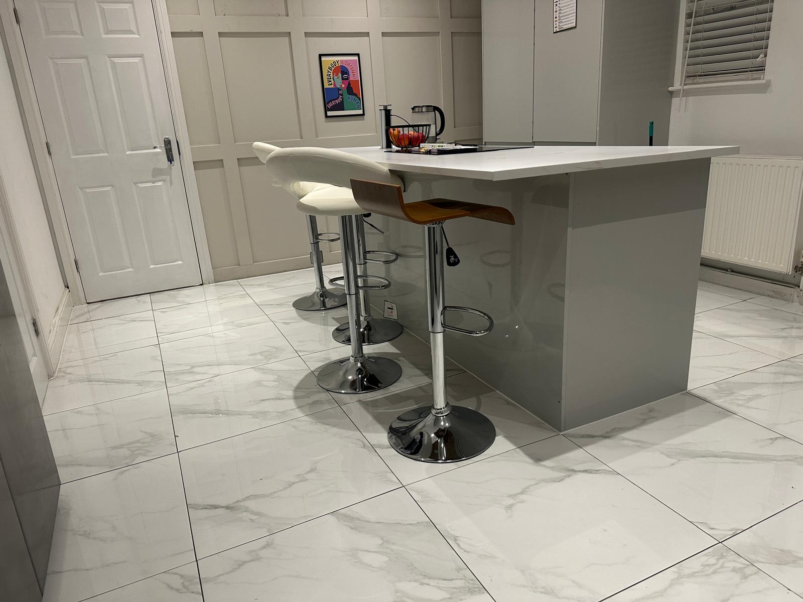 White kitchen island, stools and tiled floor in the Winter Park home