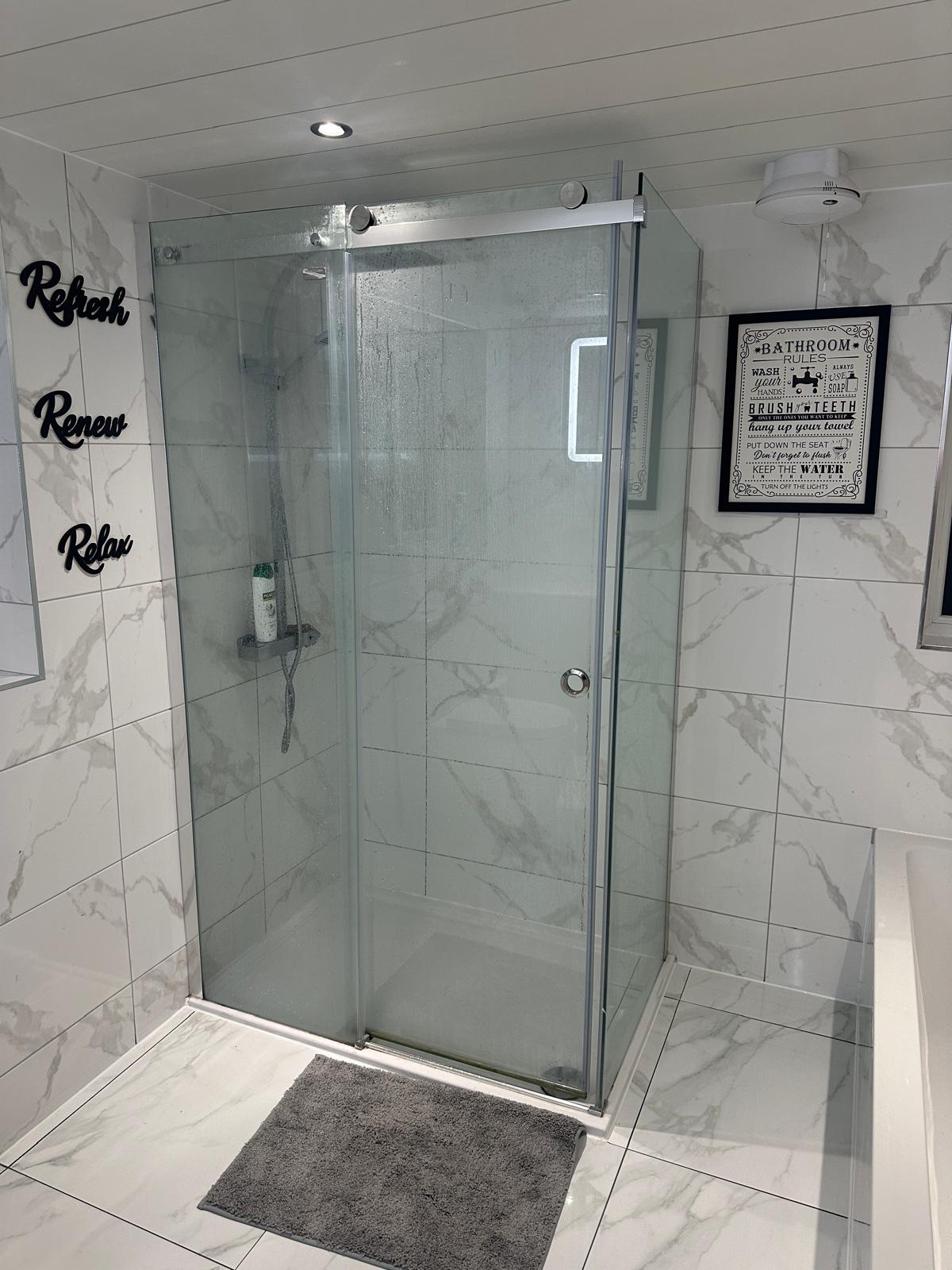 Glass shower enclosure and marble-effect tile in the Winter Park bathroom